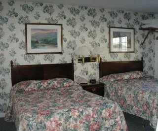 A room with a queen bed and a double bed